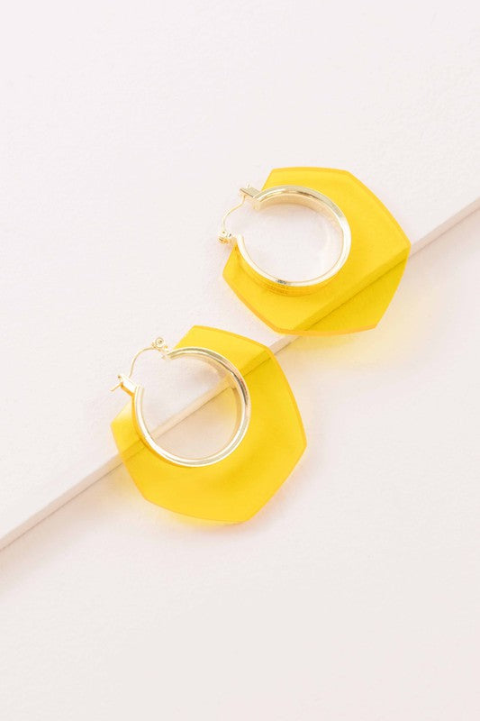 A pair of Angled Clear Hoop Earrings displayed on a white surface.