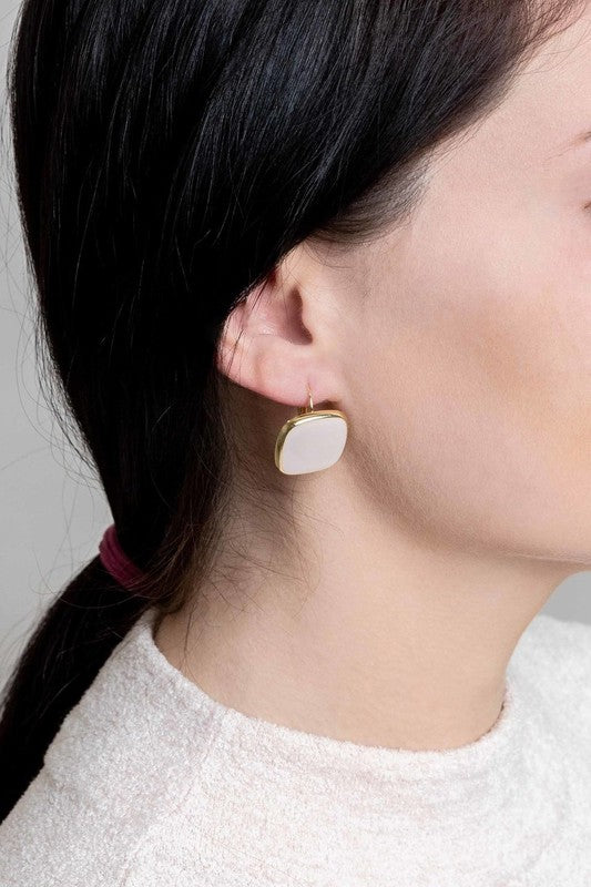 The On the Go Hook Earrings 14K, a pair of square, yellow earrings with 14K gold plate trim, rest on a white surface, bringing a hint of casual style with their elegant yet understated design.