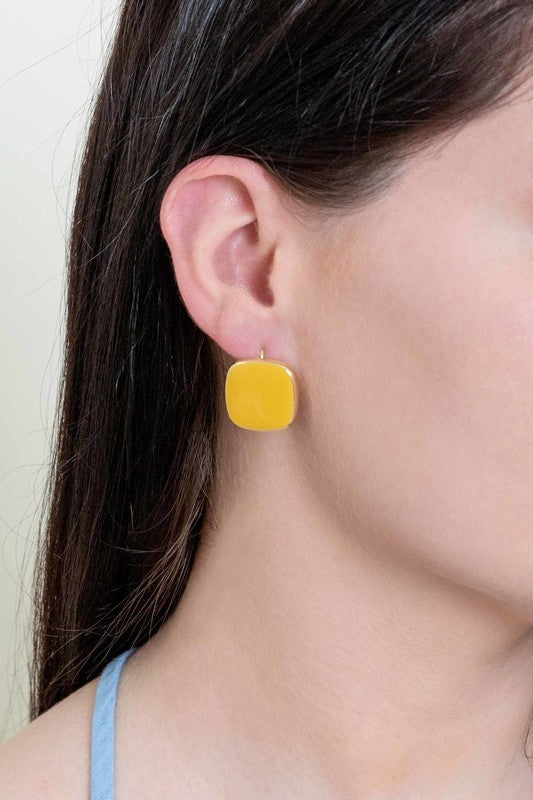 The On the Go Hook Earrings 14K, a pair of square, yellow earrings with 14K gold plate trim, rest on a white surface, bringing a hint of casual style with their elegant yet understated design.