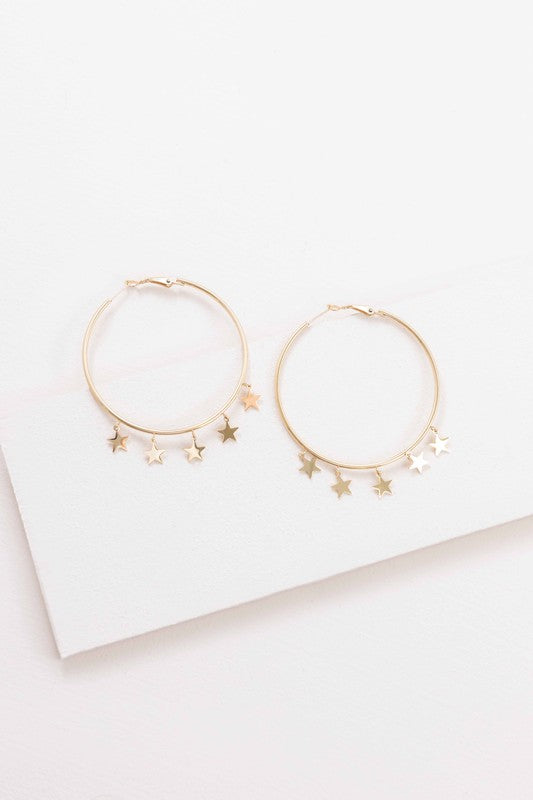 A pair of Night Dreamer Hoop Earrings with celestial star charms on a white background.