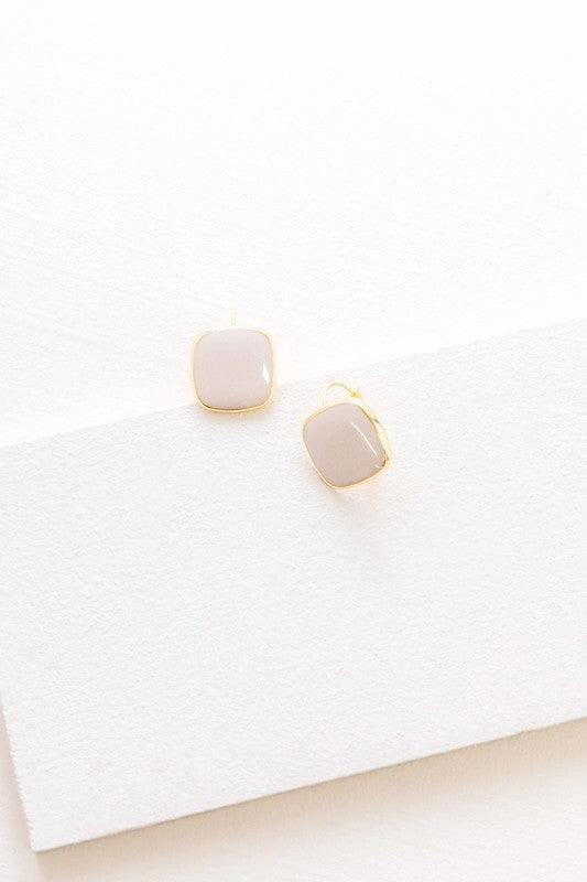 The On the Go Hook Earrings 14K, a pair of square, yellow earrings with 14K gold plate trim, rest on a white surface, bringing a hint of casual style with their elegant yet understated design.