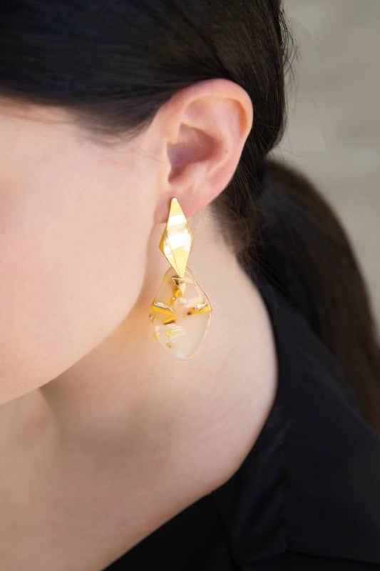 A pair of Yellow Drip dangle earrings with floral inclusions on a white background.