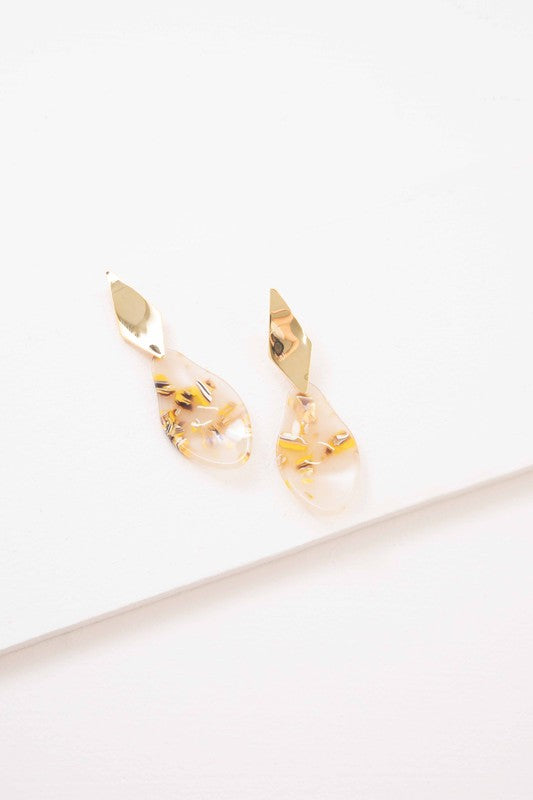 A pair of Yellow Drip dangle earrings with floral inclusions on a white background.