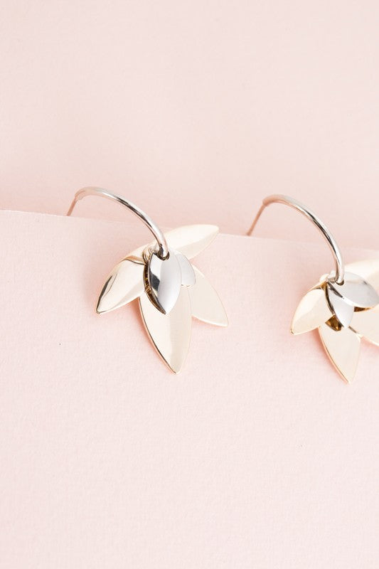 A pair of Two-Tone Lotus Hoop Earrings on a pale pink background.