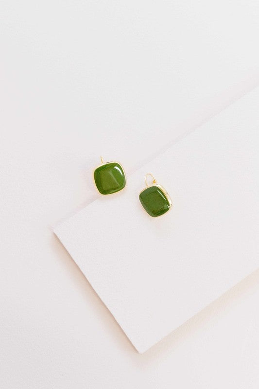 The On the Go Hook Earrings 14K, a pair of square, yellow earrings with 14K gold plate trim, rest on a white surface, bringing a hint of casual style with their elegant yet understated design.