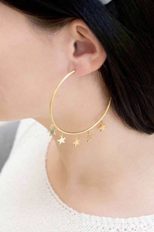 A pair of Night Dreamer Hoop Earrings with celestial star charms on a white background.