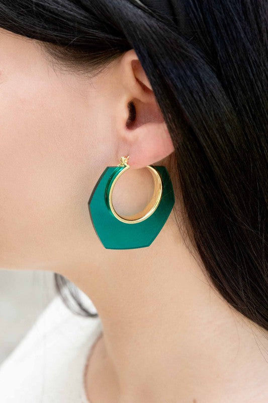 A pair of Angled Clear Hoop Earrings displayed on a white surface.