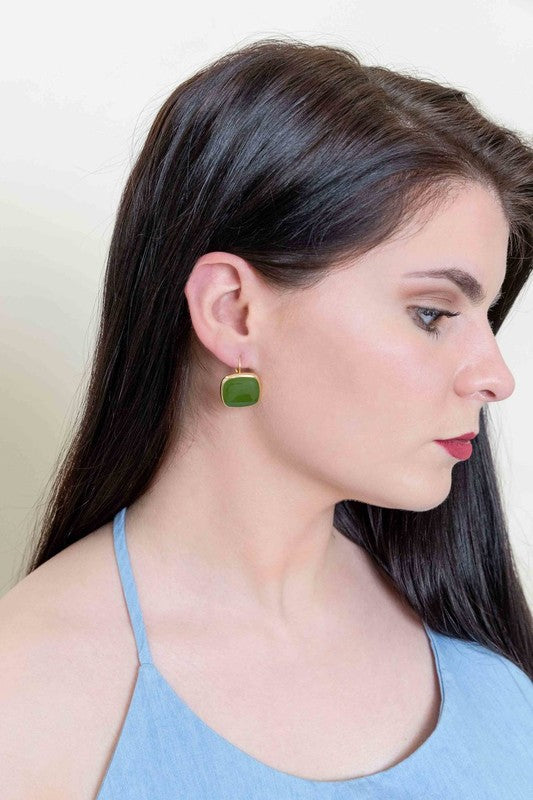 The On the Go Hook Earrings 14K, a pair of square, yellow earrings with 14K gold plate trim, rest on a white surface, bringing a hint of casual style with their elegant yet understated design.