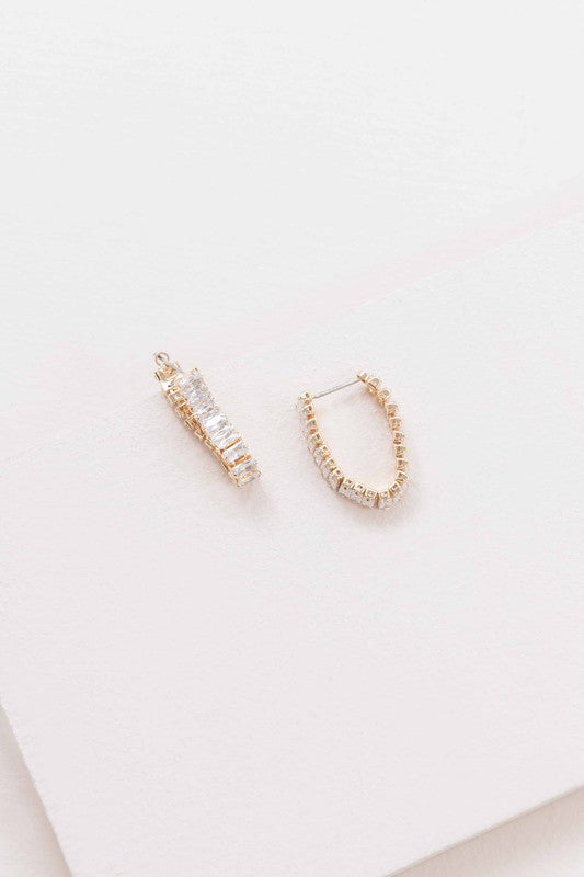 A pair of Pure Glam Drop Earrings with glamour stones on a white surface.