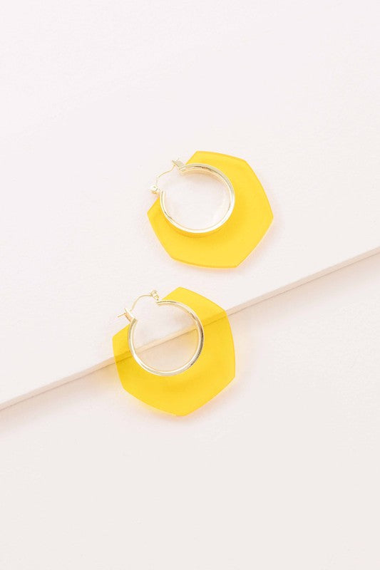 A pair of Angled Clear Hoop Earrings displayed on a white surface.