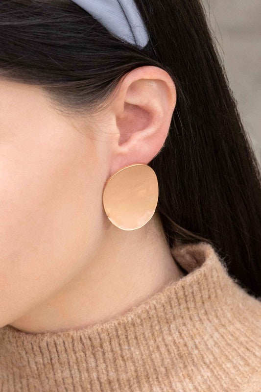 Round beige On a Curve stud earrings with a gold rim on a thin line against a white background.