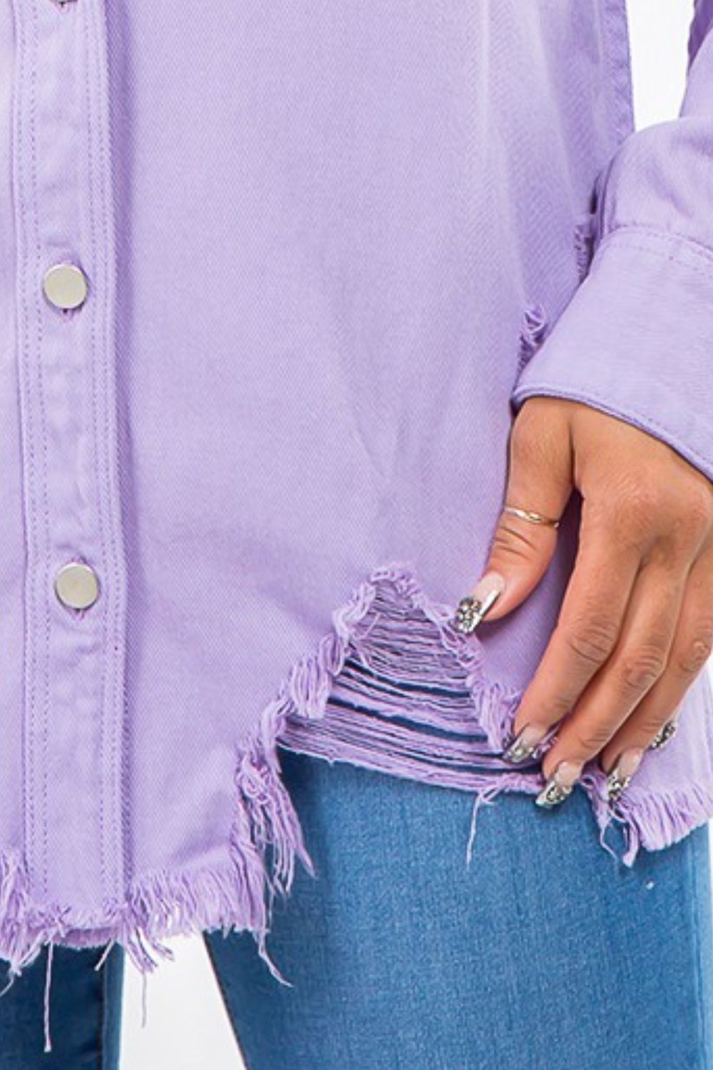 A person wearing an American Bazi Frayed Hem Distressed Denim Jacket over a light purple button-up shirt with a vintage look, paired with distressed denim jeans, standing against a plain background.