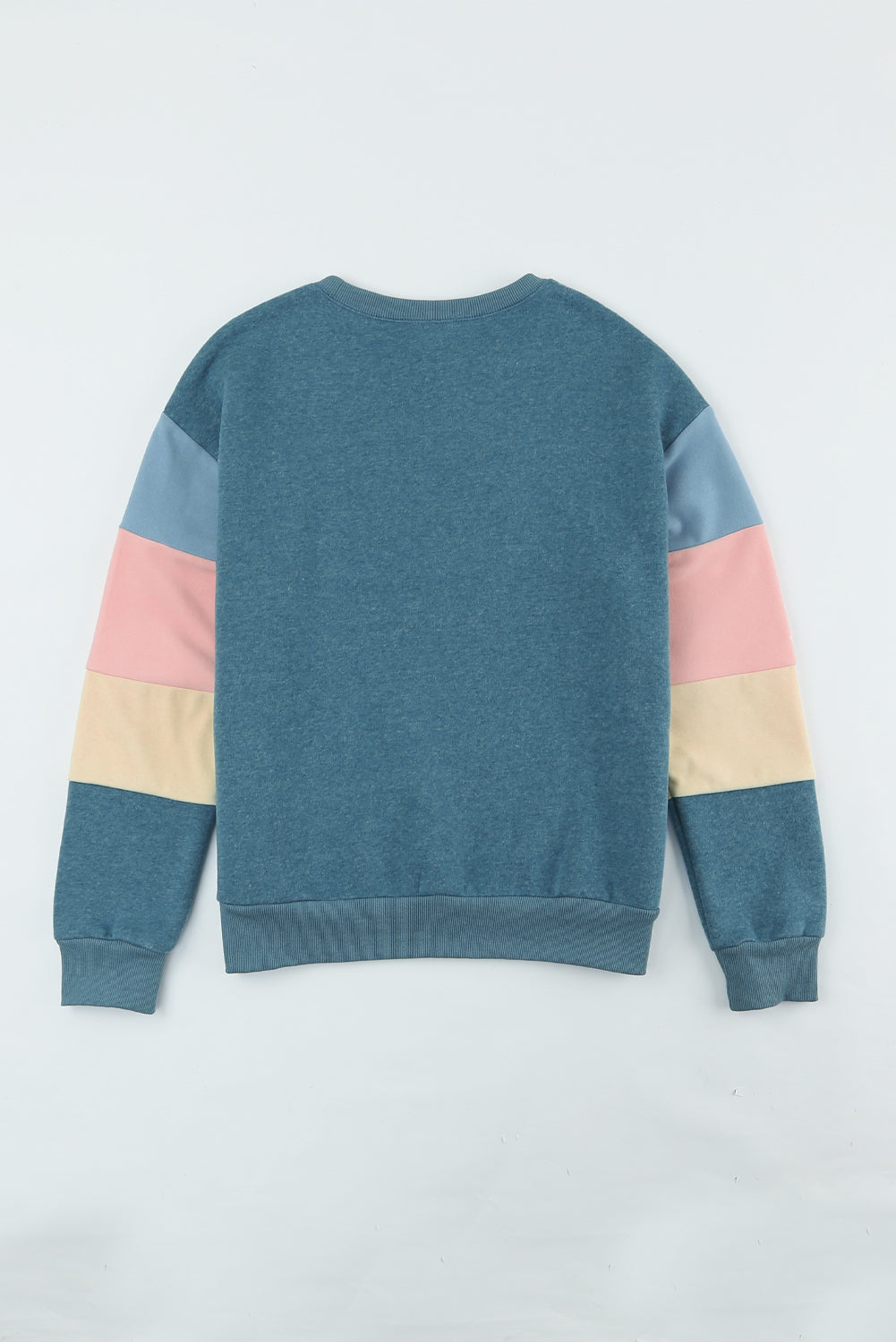 A rear view of a person with wavy hair, dressed in a Blue Colorblock Long Sleeve Pullover Sweatshirt and light blue jeans, hands resting on their hips. Perfect for winter fashion, this versatile piece is an ideal addition to any wardrobe.