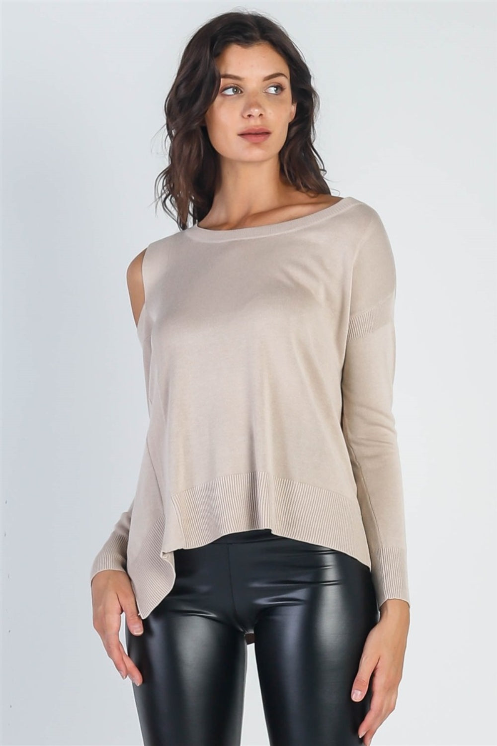 A person wearing the UNIQ Cold Shoulder Long Sleeve Knit Top in black and distressed denim shorts stands against a plain white background, effortlessly showcasing a versatile wardrobe choice.