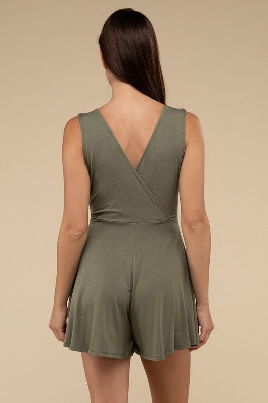 A woman stands posing in a studio, wearing a Surplice Neckline Sleeveless Romper in olive green and beige high-heeled sandals.