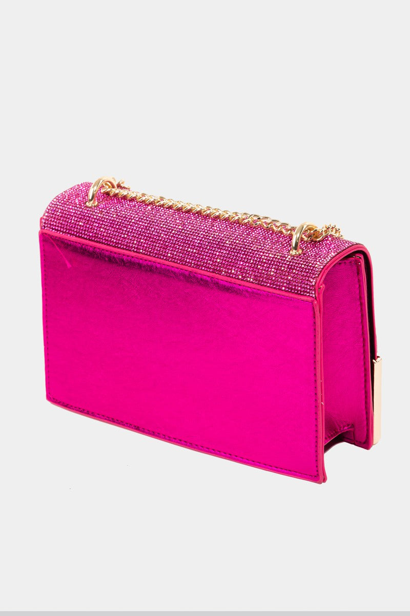 The Fame Rhinestone Studded Rectangle Crossbody Bag is a glamorous pink shoulder bag featuring a gold chain strap and metal corners, making it the perfect medium PU bag to add a touch of elegance to any outfit.