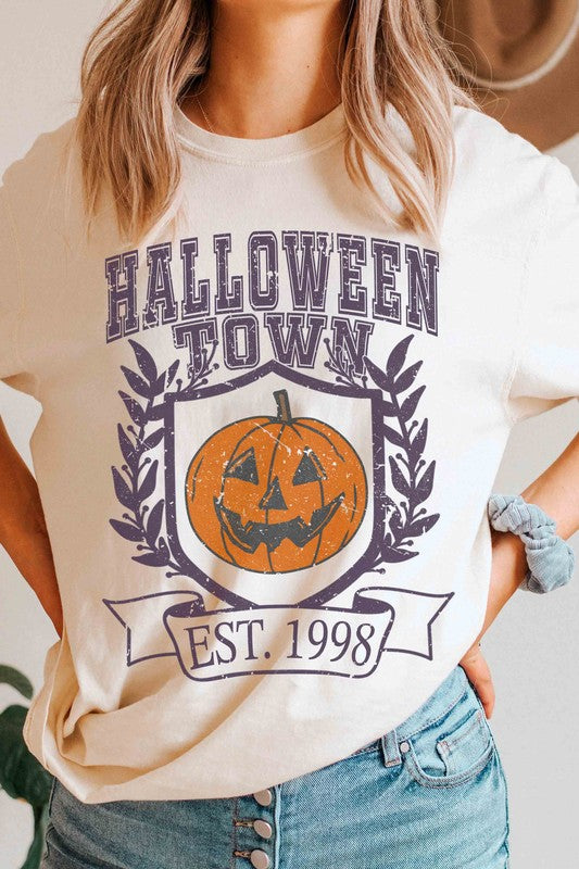 A person wearing a premium cotton HALLOWEEN TOWN Graphic Tee featuring an est. 1998 jack-o'-lantern design, displaying a peace sign with their right hand.