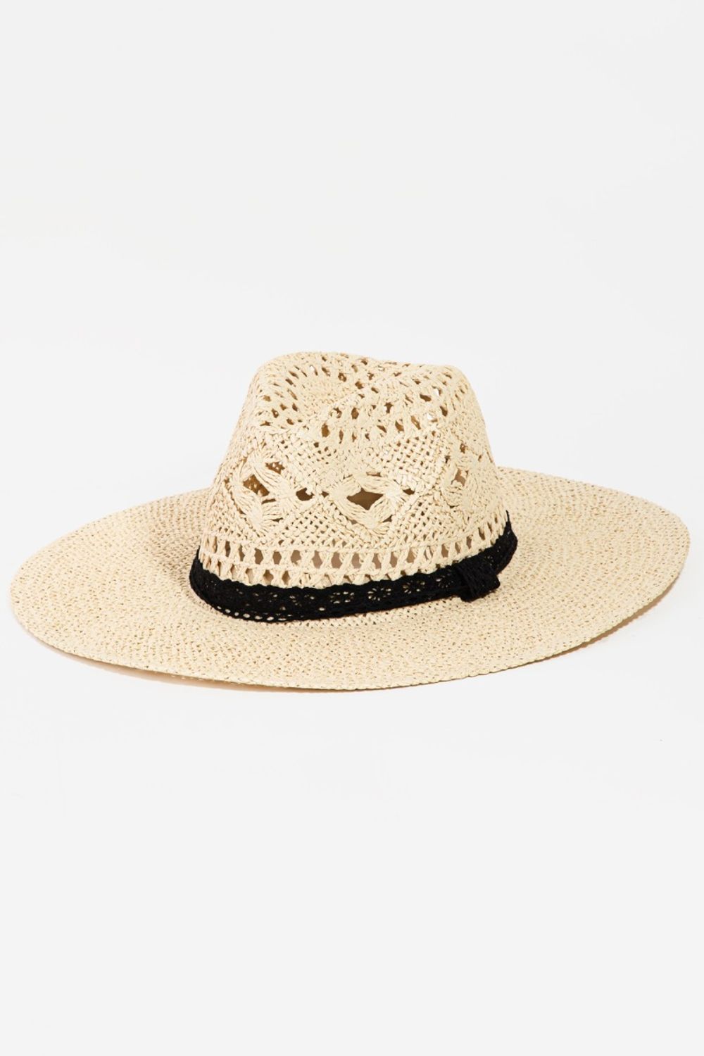 The Fame Openwork Lace Detail Wide Brim Hat is an elegant straw hat with a black trim, featuring intricate openwork lace that provides enhanced sun protection on a white background.