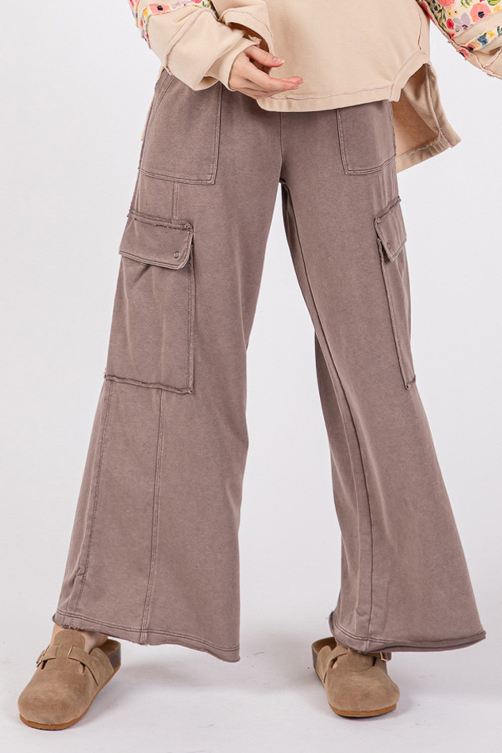 A person wearing SAGE + FIG Knit Terry Mineral Wash Wide Leg Pants in brown and beige shoes stands against a plain background.