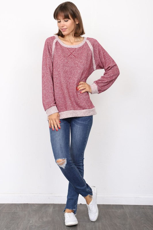 Person wearing a brown Plus Shimmer French Terry Top, blue jeans, and white sneakers, standing against a white background.