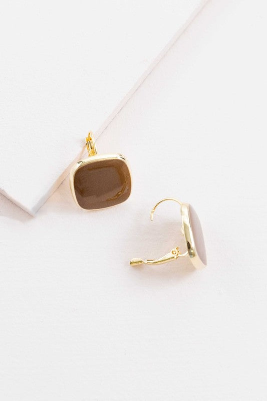 The On the Go Hook Earrings 14K, a pair of square, yellow earrings with 14K gold plate trim, rest on a white surface, bringing a hint of casual style with their elegant yet understated design.