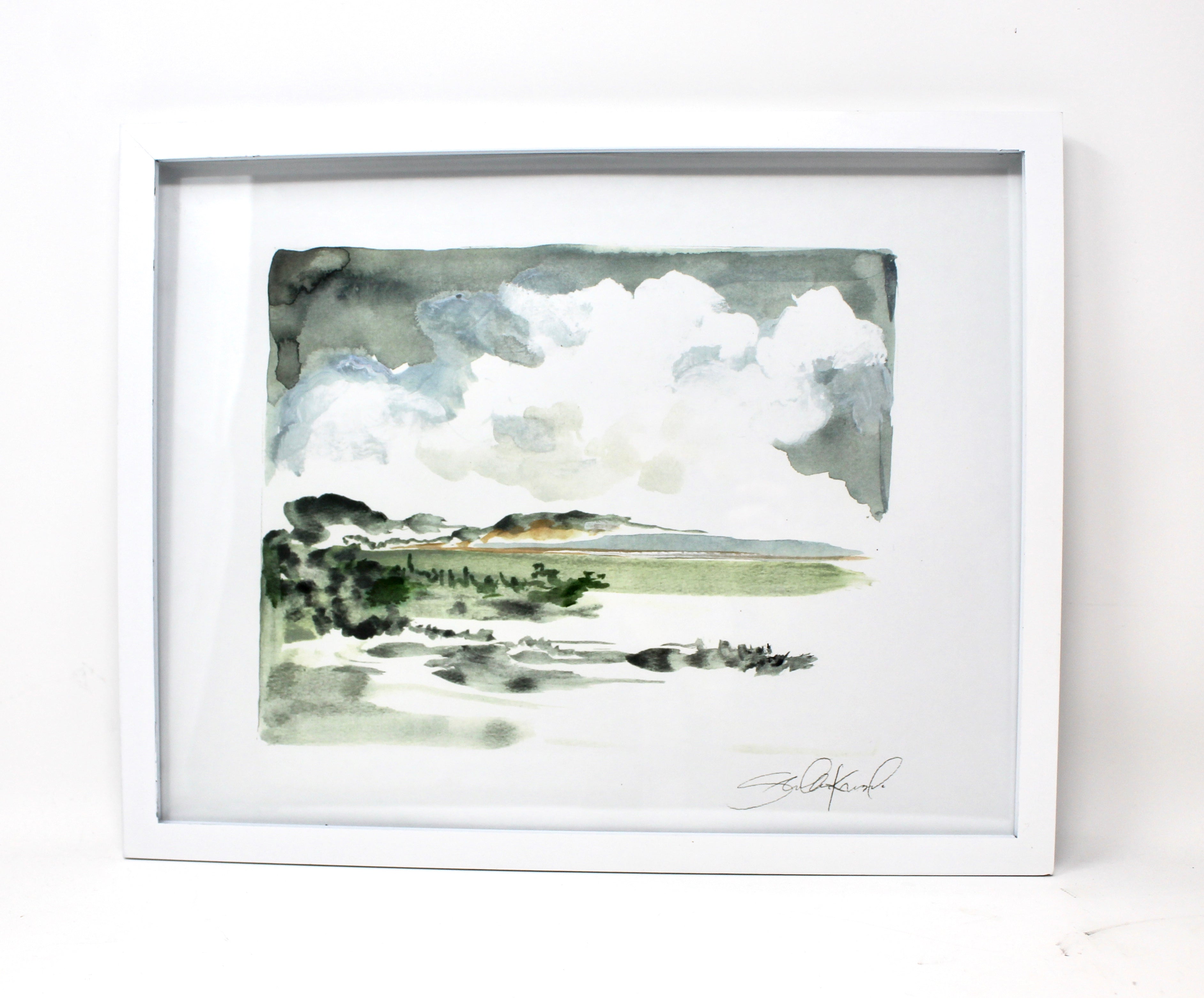 Framed 11x14 print of the "Simple Landscape Watercolor," featuring a depiction of trees, fields, and a cloudy sky on recycled paper.