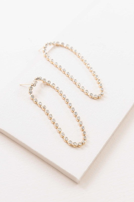 A pair of Can't Get Enough Drop Earrings with embedded crystals on a light background.