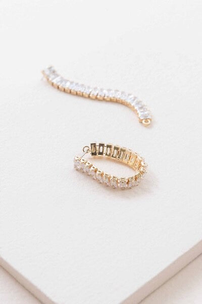 A pair of Pure Glam Drop Earrings with glamour stones on a white surface.