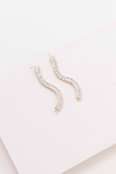 A pair of Pure Glam Drop Earrings with glamour stones on a white surface.