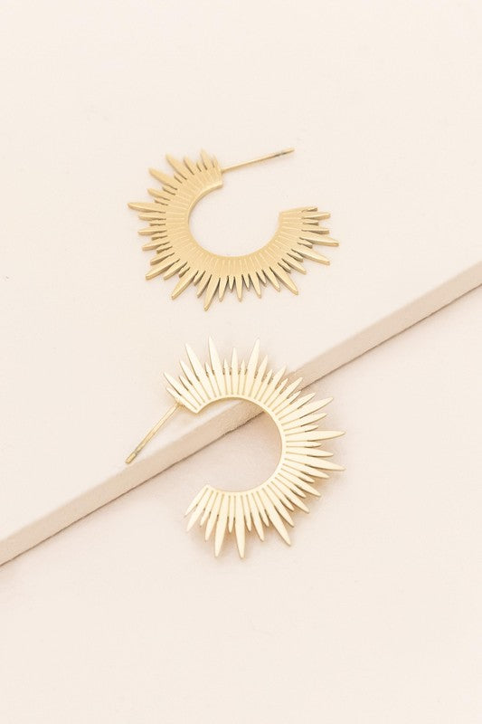 Rays Of Light Hoops sunburst earrings on a pale background.