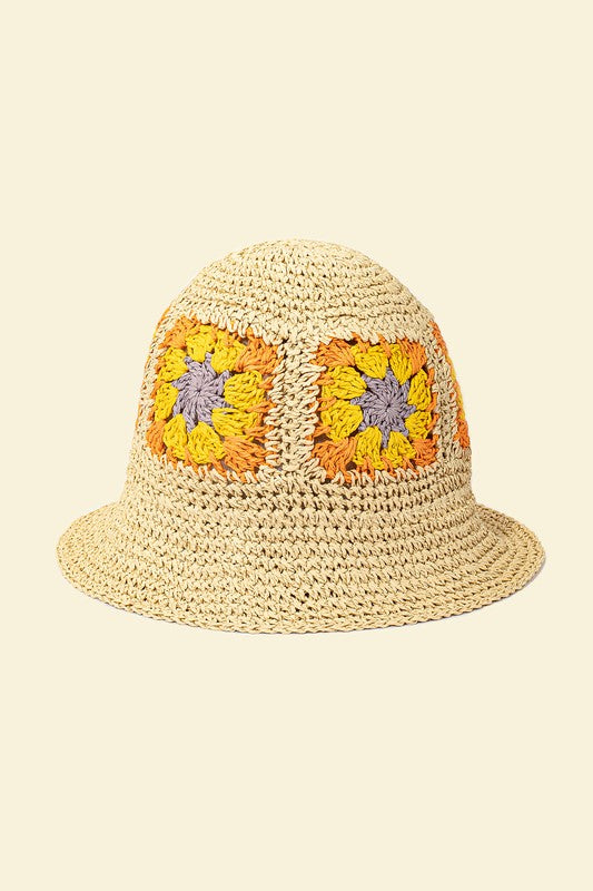 A set of four packable crochet granny square bucket hats in beige, black, and charming patterns featuring yellow flower designs, all lovingly hand-crocheted to perfection.