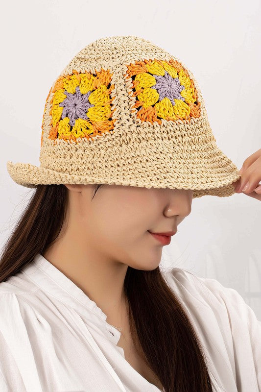 A set of four packable crochet granny square bucket hats in beige, black, and charming patterns featuring yellow flower designs, all lovingly hand-crocheted to perfection.