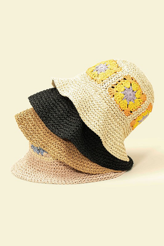 A set of four packable crochet granny square bucket hats in beige, black, and charming patterns featuring yellow flower designs, all lovingly hand-crocheted to perfection.