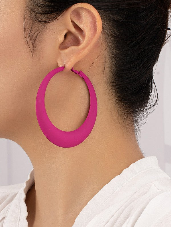 Four large color coated puffy hoop earrings, available in off-white, pink, blue, and black hues, are neatly displayed on a beige surface and white platform.