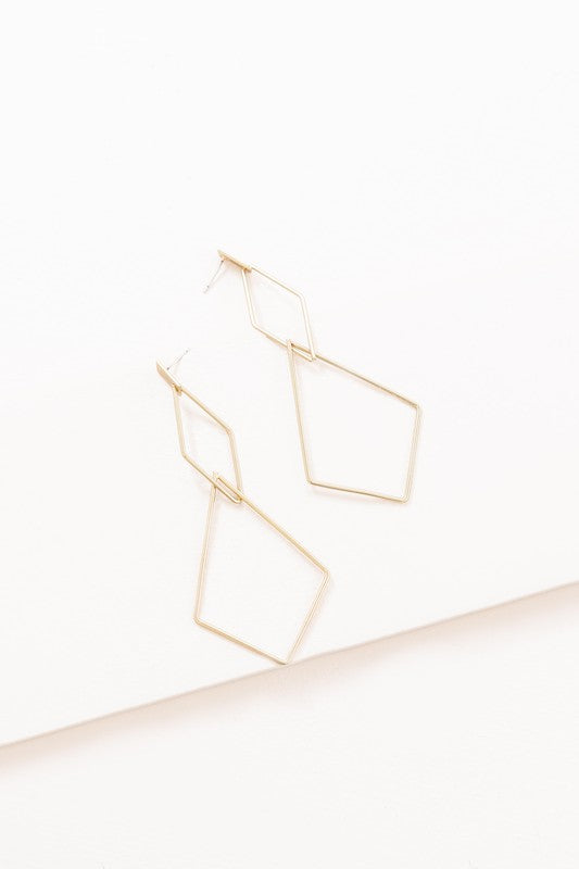 The Shape Of You Drop Earrings, featuring geometric and angular abstract designs crafted in sterling silver, are displayed against a plain white background.