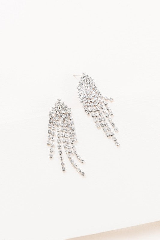 The Rhinestone Tassel Earrings exude Hollywood glam with their silver, dangling design set against a light background, featuring multiple cascading strands that epitomize formal jewelry elegance.