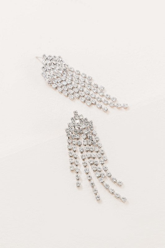 The Rhinestone Tassel Earrings exude Hollywood glam with their silver, dangling design set against a light background, featuring multiple cascading strands that epitomize formal jewelry elegance.