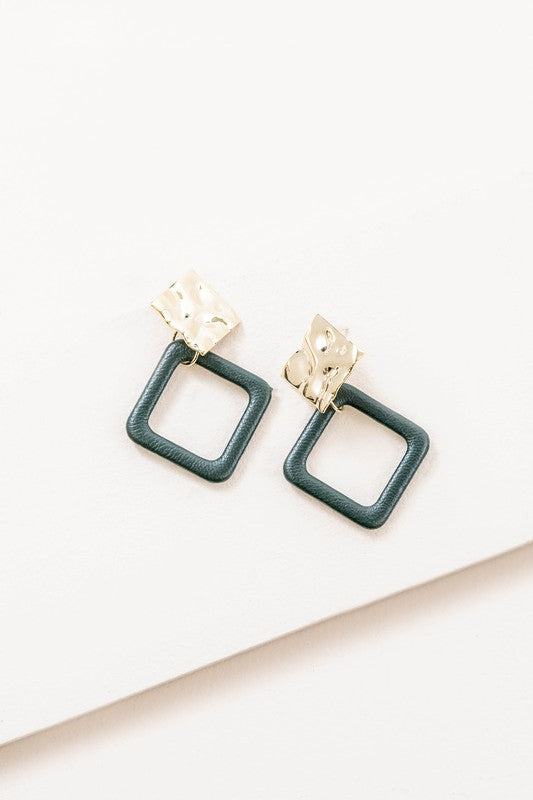 The Leatherette and Metal Drop Earrings showcase a bold design with two hammered 14k gold-plated brass squares linked to orange leather-like square loops.