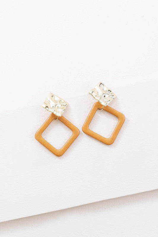 The Leatherette and Metal Drop Earrings showcase a bold design with two hammered 14k gold-plated brass squares linked to orange leather-like square loops.