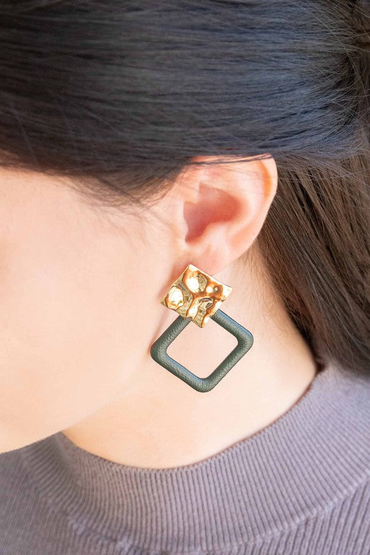 The Leatherette and Metal Drop Earrings showcase a bold design with two hammered 14k gold-plated brass squares linked to orange leather-like square loops.