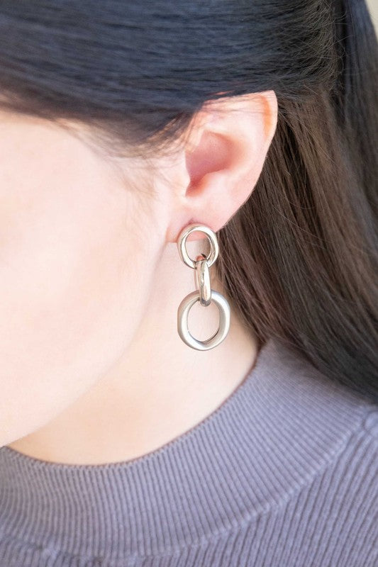 The Let's Link Up Earrings, featuring a pair of gun-metal chained drop design with sterling silver posts, are elegantly showcased on a light background.