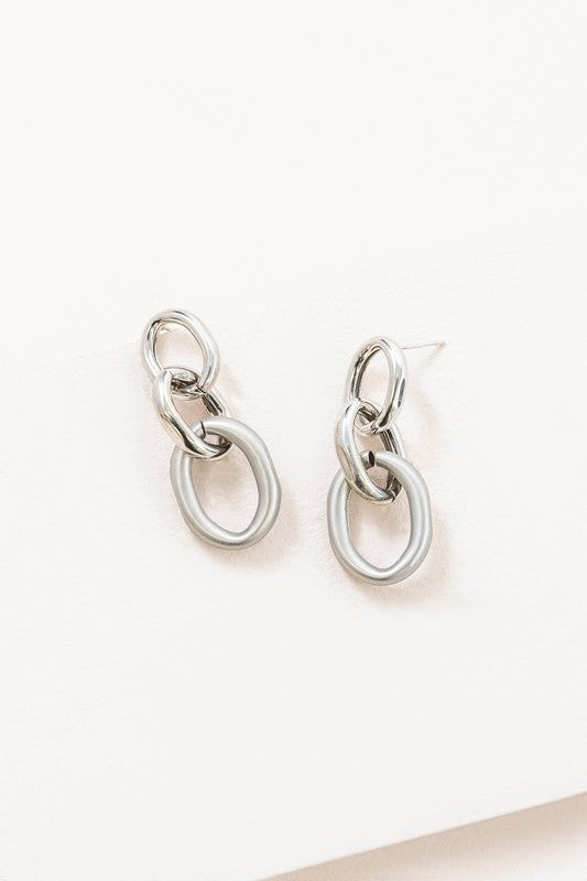 The Let's Link Up Earrings, featuring a pair of gun-metal chained drop design with sterling silver posts, are elegantly showcased on a light background.