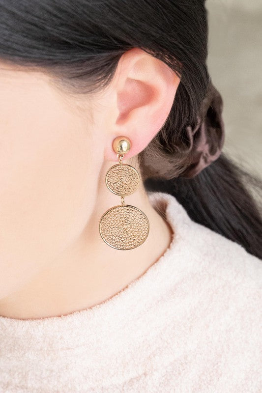 The exquisite Golden Webbed Earrings, crafted from brass with a gold-tone finish, showcase round, three-tiered drop earrings featuring an intricate webbed lattice design and are elegantly displayed on a white surface.