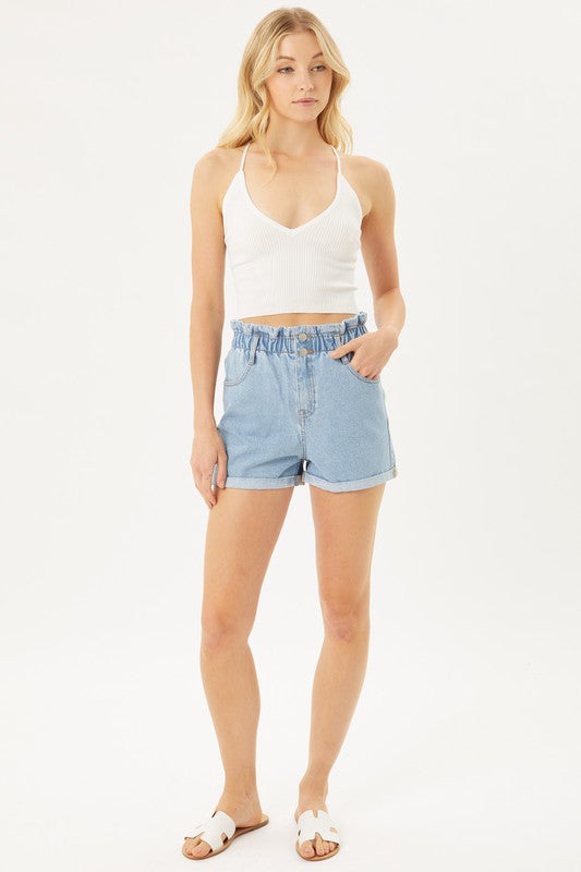 A person wearing light blue Double Buttoned Waistband Denim Shorts with rolled hems, paired with a white ribbed top.