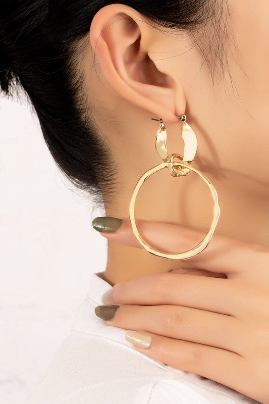 The product, "Statement hammered hoop drop earrings," showcases large, gold-plated hoops with textured surfaces, elegantly displayed on a white background.