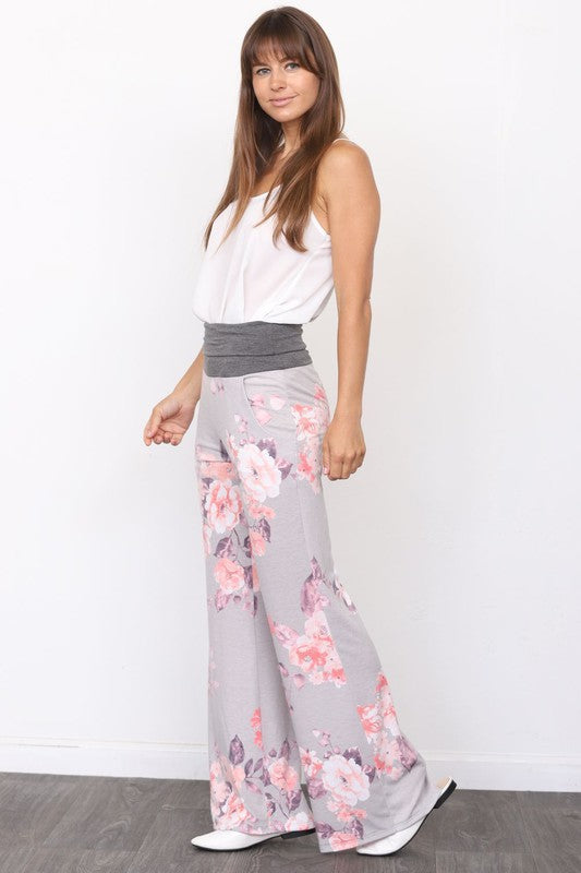 A person wearing Vintage Floral Wide Leg Pants paired with a white sleeveless top stands against a plain background.