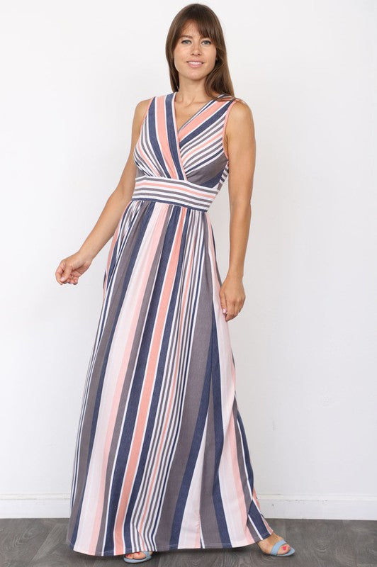 A person wearing a sleeveless, floor-length Surplice Stripe Maxi Dress with vertical yellow, blue, gray, and white stripes stands against a plain background.