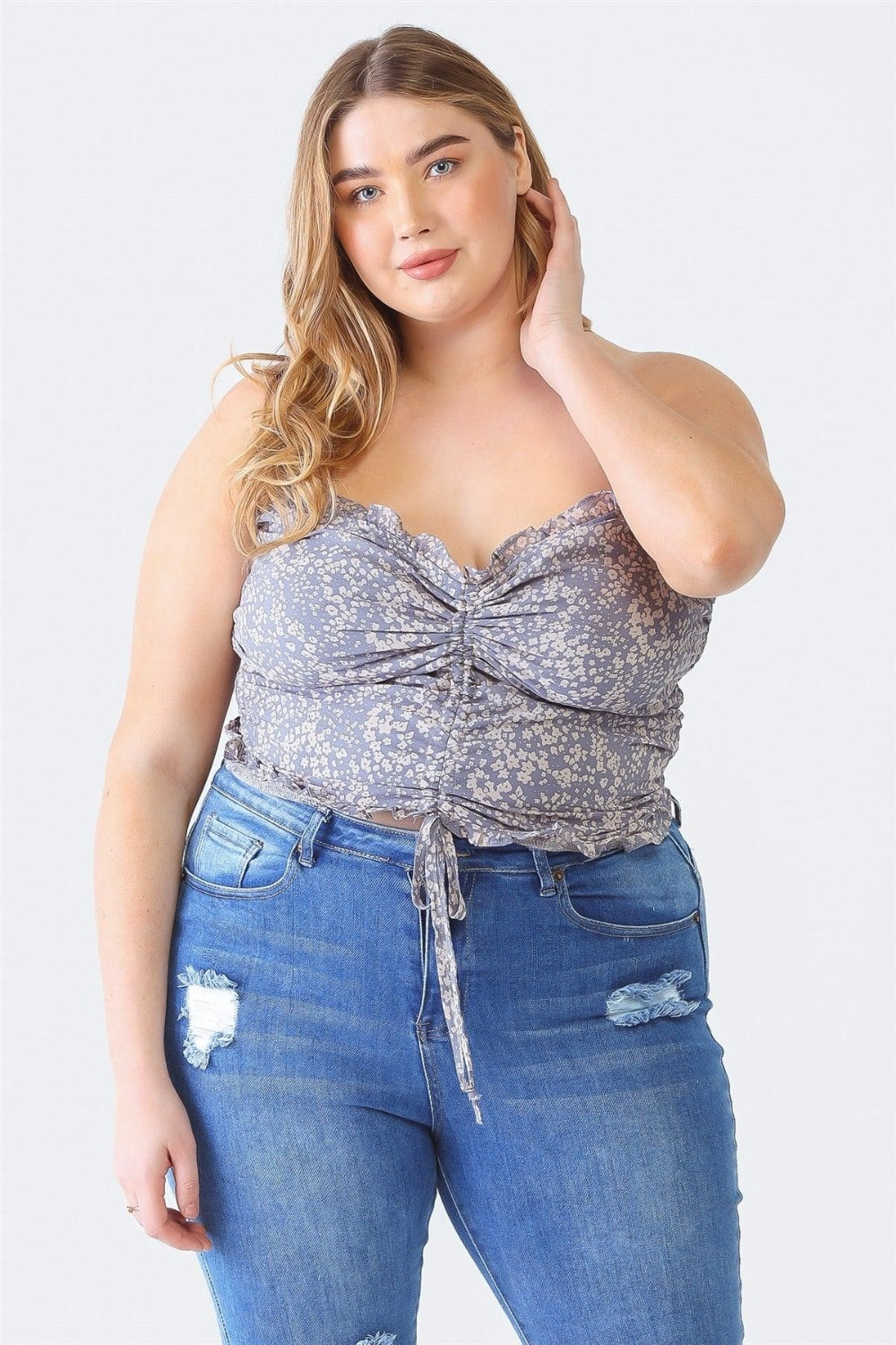 A person with long hair is wearing the Zenobia Plus Size Drawstring Smocked Floral Tube Top paired with ripped jeans, standing against a plain background—a perfect addition to any summer wardrobe.