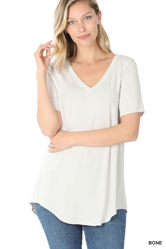 A woman is wearing a Luxe Rayon Short Sleeve V-Neck Hi-Low Hem Top paired with blue jeans.