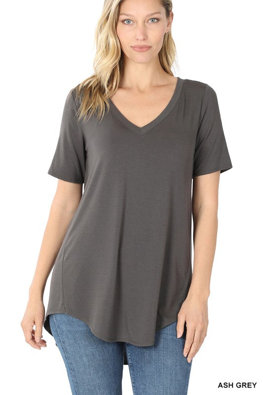 A woman is wearing a Luxe Rayon Short Sleeve V-Neck Hi-Low Hem Top paired with blue jeans.